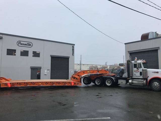 Orange tri-axle 55 ton lowbed with wood deck, hitched for winter delivery at the Pacesetter yard, photo 11 of 14