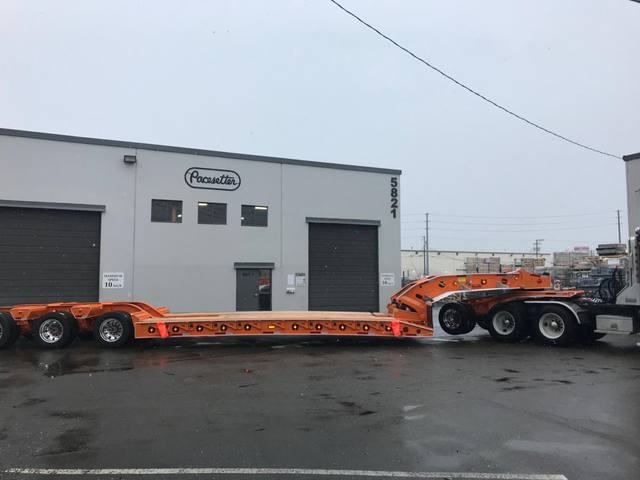 Orange tri-axle 55 ton lowbed with wood deck, hitched for winter delivery at the Pacesetter yard, photo 12 of 14
