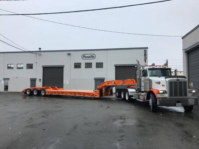 Orange tri-axle 55 ton lowbed with wood deck, hitched for winter delivery at the Pacesetter yard, photo 13 of 14
