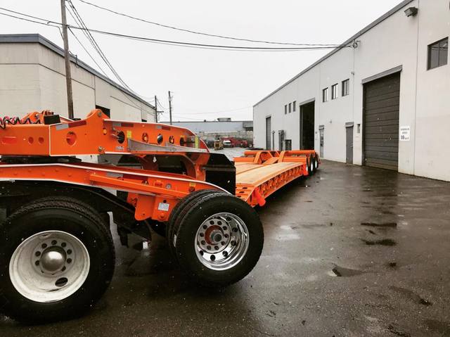 Orange tri-axle 55 ton lowbed with wood deck, hitched for winter delivery at the Pacesetter yard, photo 14 of 14