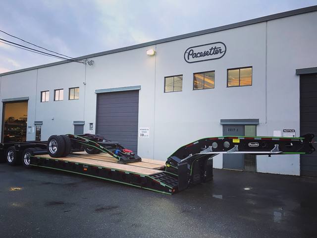 Black 55 ton lowbed with green pinstriping at dusk, booster axle carried on the deck, photo 1 of 2