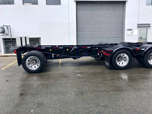 Black 60 ton lowbed with blue pinstriping and a pin-on booster behind a white Kenworth, photo 4 of 5