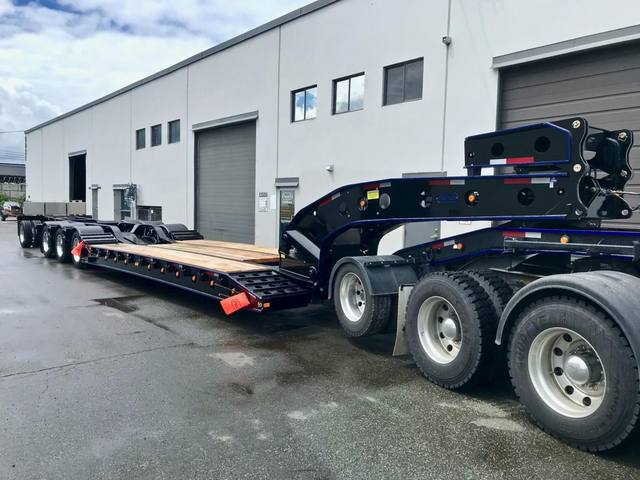 Black 60 ton lowbed with blue pinstriping and a pin-on booster behind a white Kenworth, photo 5 of 5