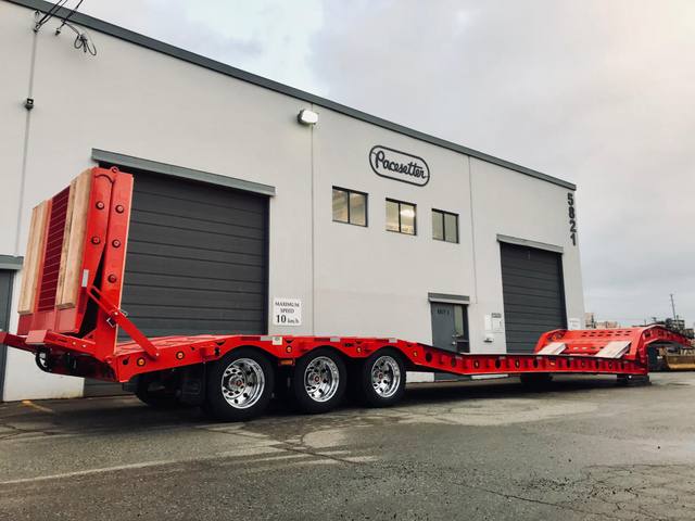 Red tri-axle paving trailer with hydraulic flip ramp at the Pacesetter plant, photo 3 of 18