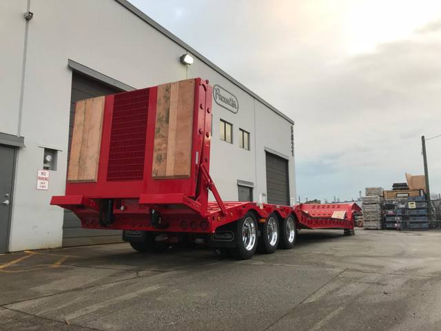 Red tri-axle paving trailer with hydraulic flip ramp at the Pacesetter plant, photo 4 of 18