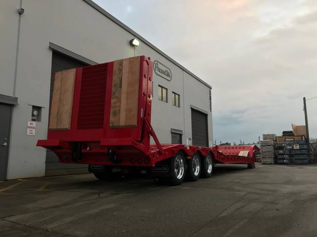 Red tri-axle paving trailer with hydraulic flip ramp at the Pacesetter plant, photo 5 of 18