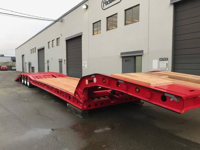 Red tri-axle paving trailer with hydraulic flip ramp at the Pacesetter plant, photo 11 of 18