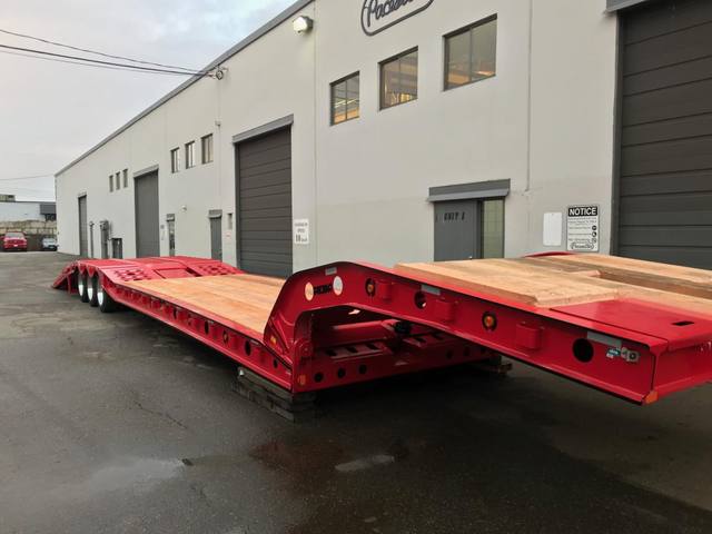 Red tri-axle paving trailer with hydraulic flip ramp at the Pacesetter plant, photo 12 of 18